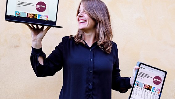 Kvinna som ler och visar upp Autism Sveriges webbplats