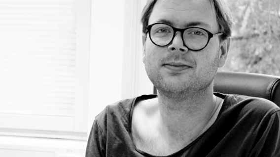 Porträttbild på Sebastian Lundström som sitter i en kontorsstol. 