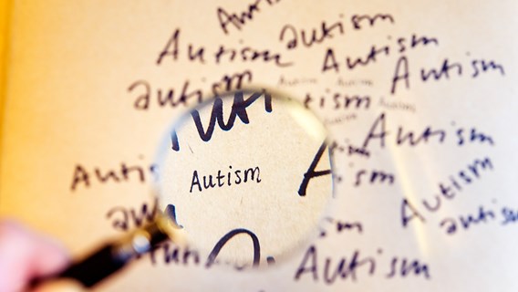 Förstoringsglas och ordet autism skrivet många gånger