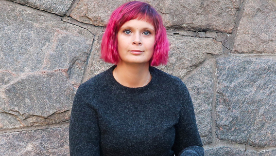 Joanna Halvardsson sitter framför järngrind