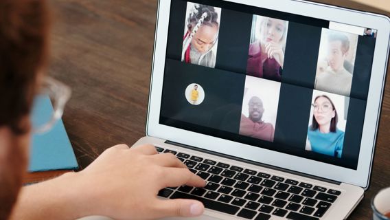 Person deltar i ett digitalt möte framför en laptop.