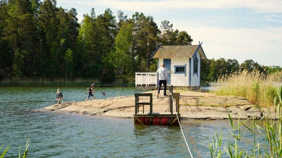 En pappa och ett barn står på en udde vid havet