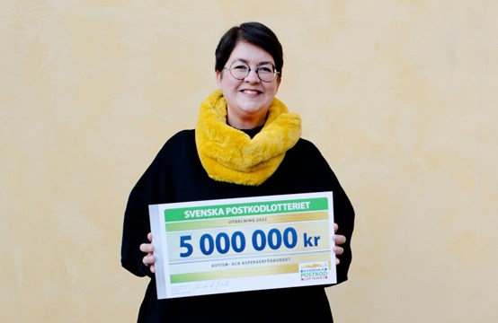 Förbundssekreterare Gunilla Sundblad håller i en bild som det står 5 000 000 kronor på